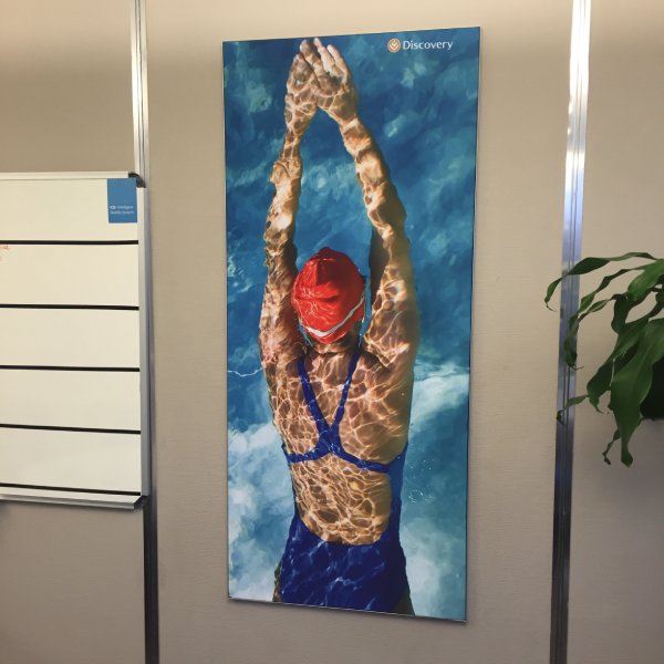Wall-mounted fabric wall frame with seamless SEG graphics for interior branding.
