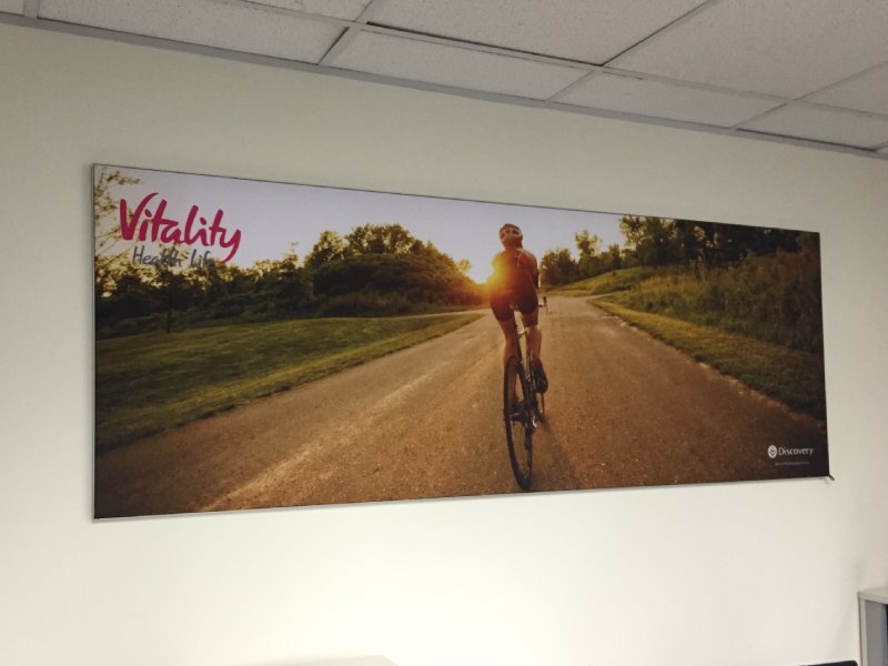 Wall-mounted fabric wall frame with seamless SEG graphics for interior branding.
